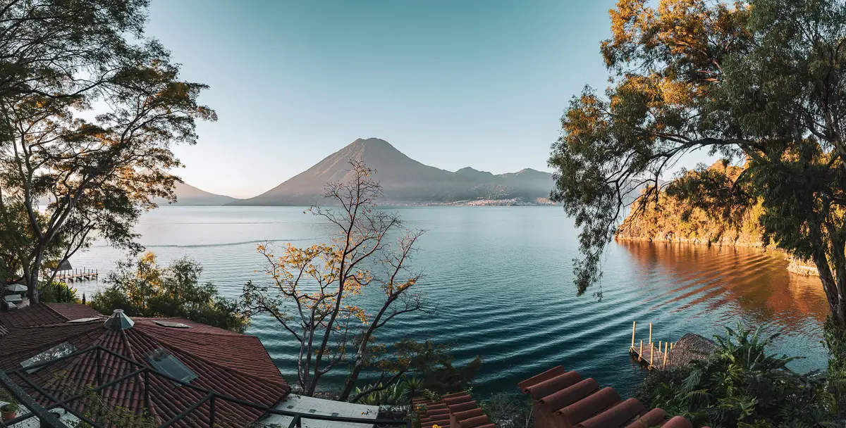 Lago Atitlán panorama framed by trees above the private cove at Casa Floresta