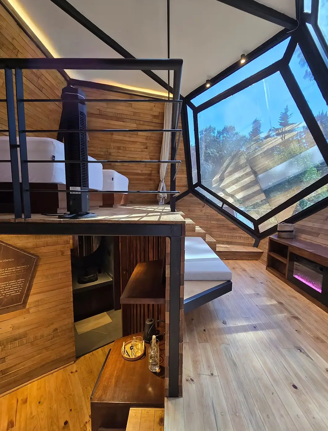 Sleeping loft and hexagonal window inside a Hunkápi cabin