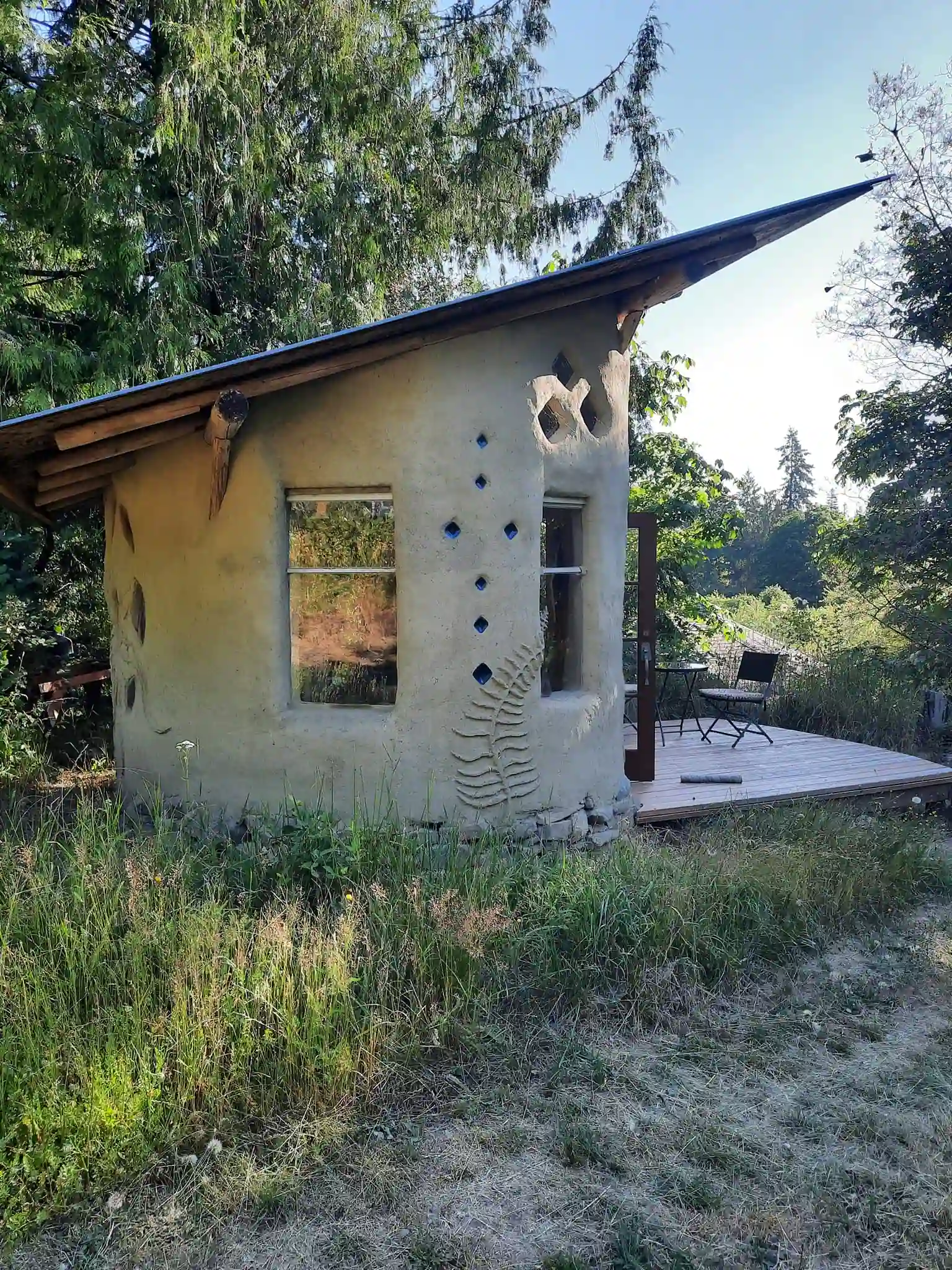 Hand-built cob house at Neptune Farm surrounded by forest on Salt Spring Island