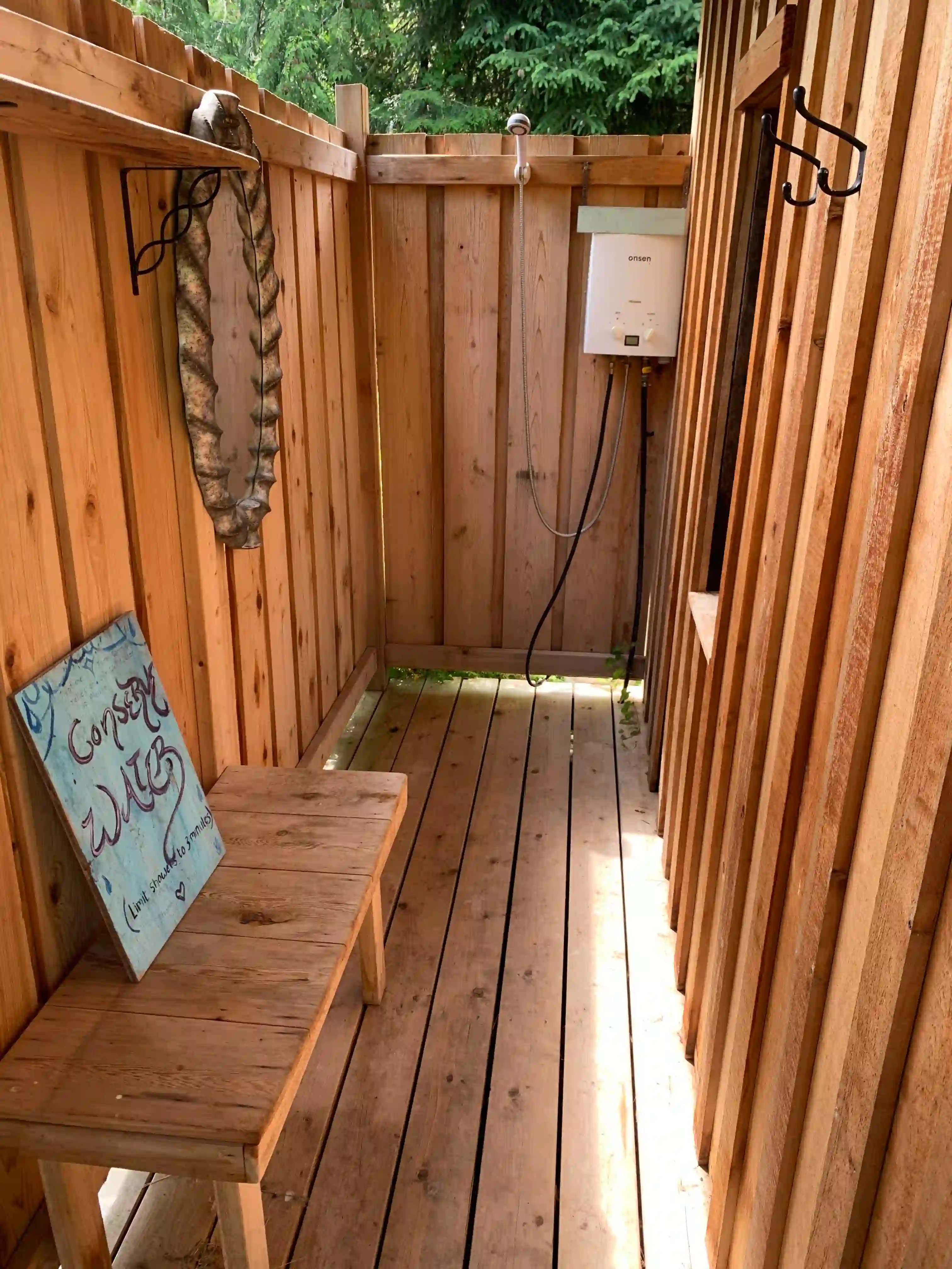 Outdoor cedar shower at Neptune Farm surrounded by trees